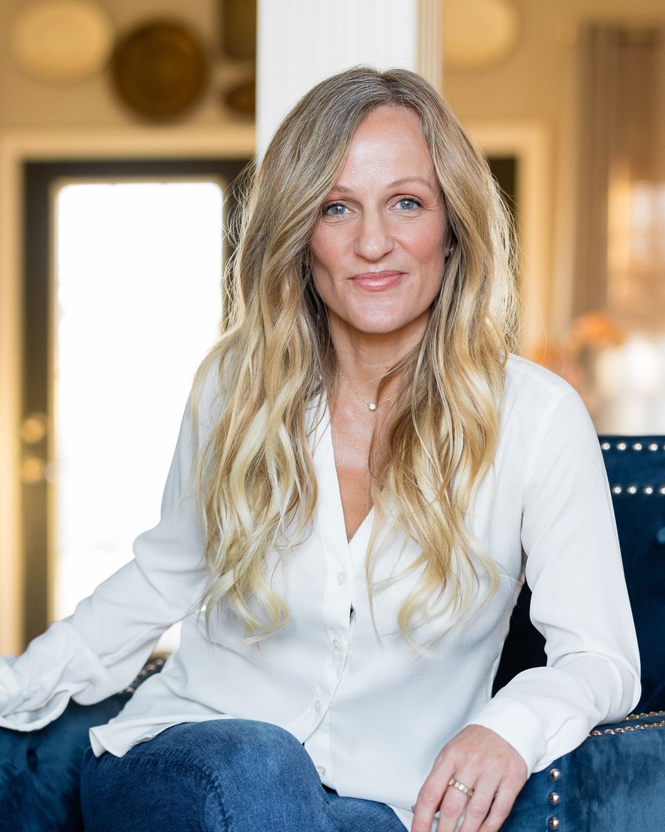Molly A. Jones, Realtor, seated in a navy velvet chair