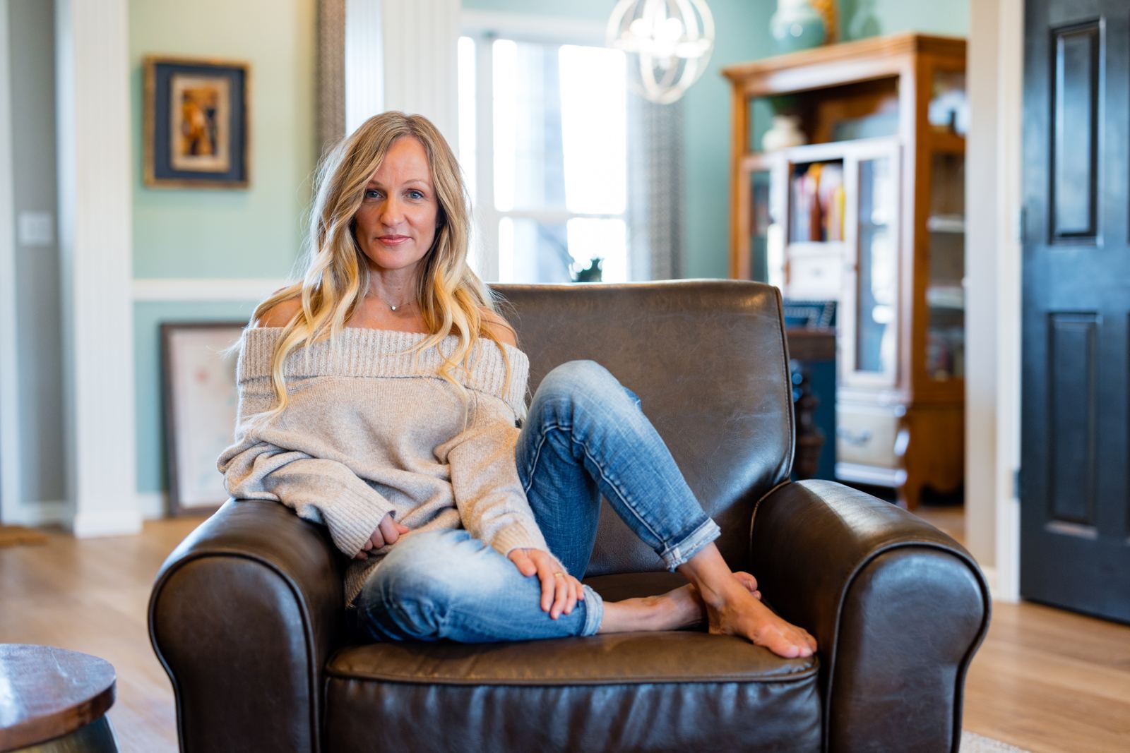 Molly A. Jones relaxing in a leather armchair at home